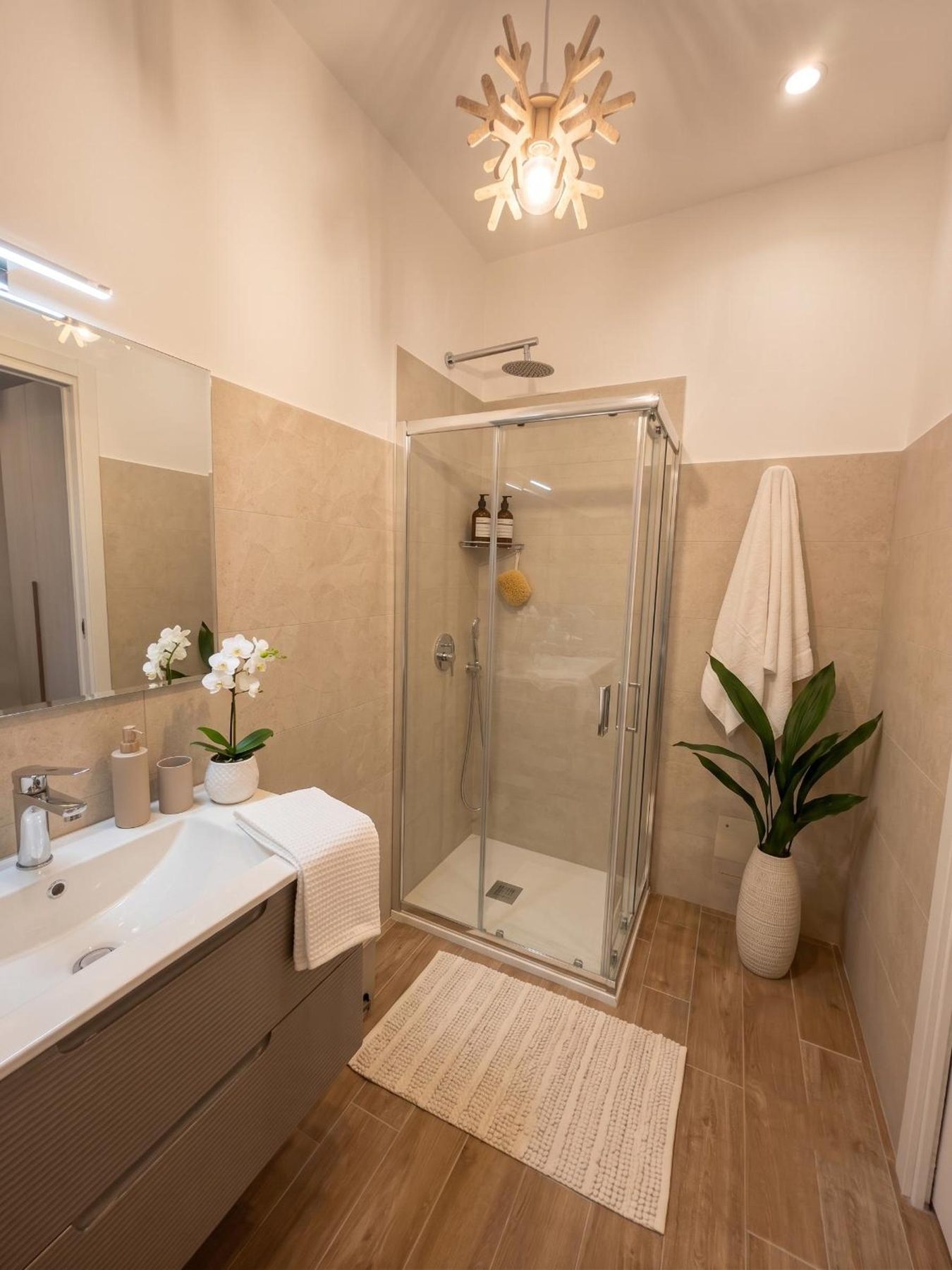 Il bagno: doccia in cristallo e lavabo con mobile