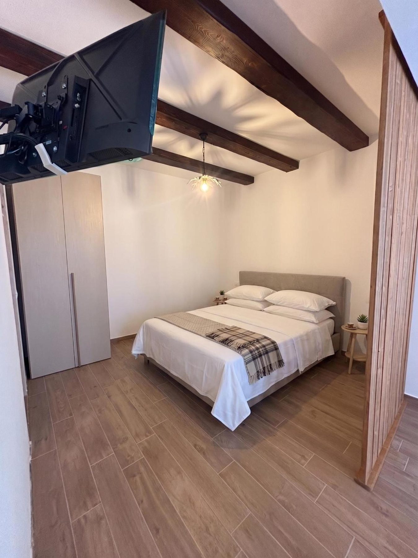 La camera vista dalla porta, con l'armadio e la televisione