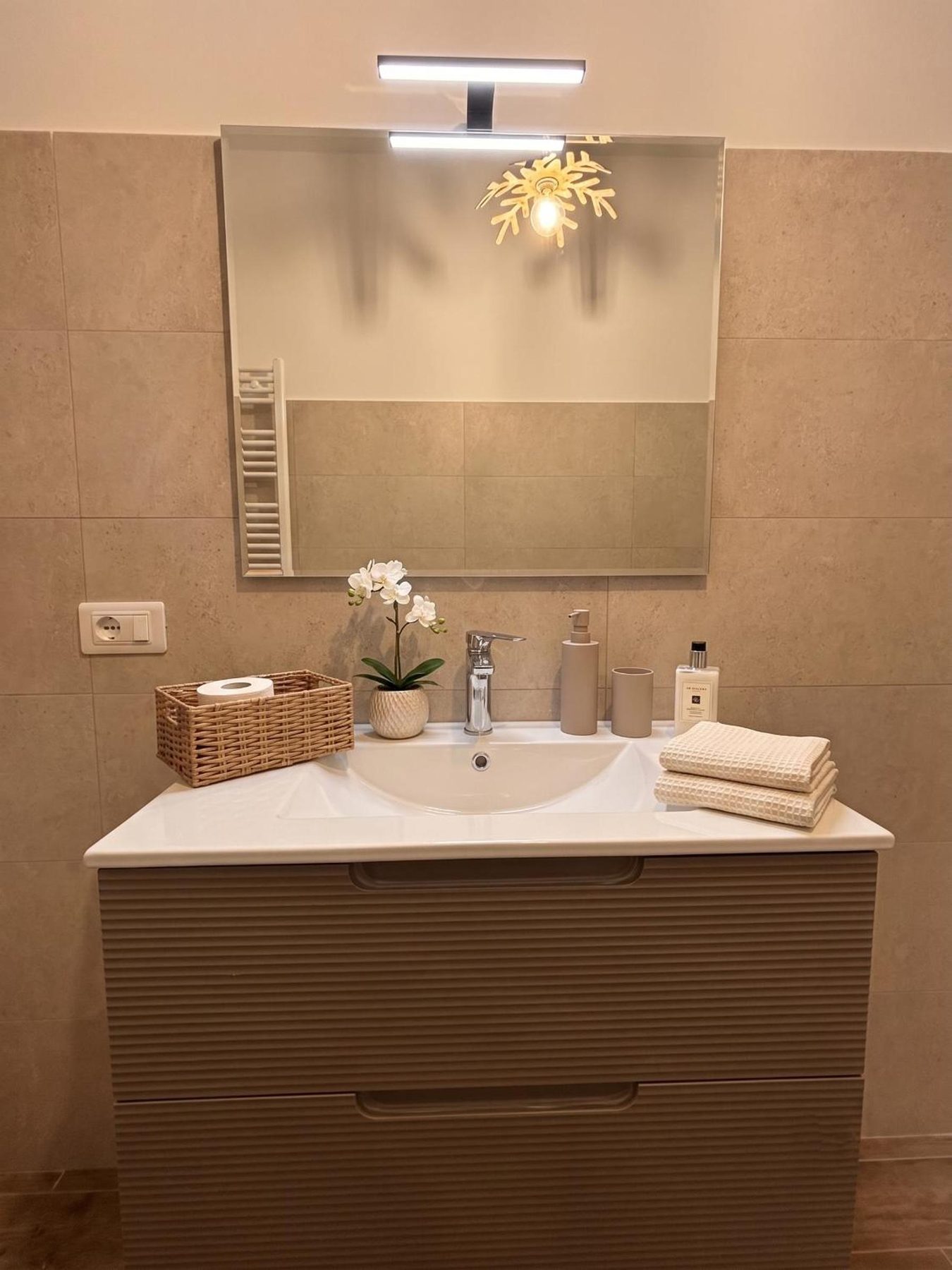 Il lavabo del bagno, con specchio e asciugamani puliti