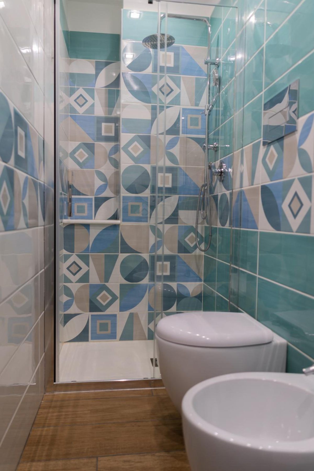 Bagno con piastrelle geometriche azzurre e la doccia