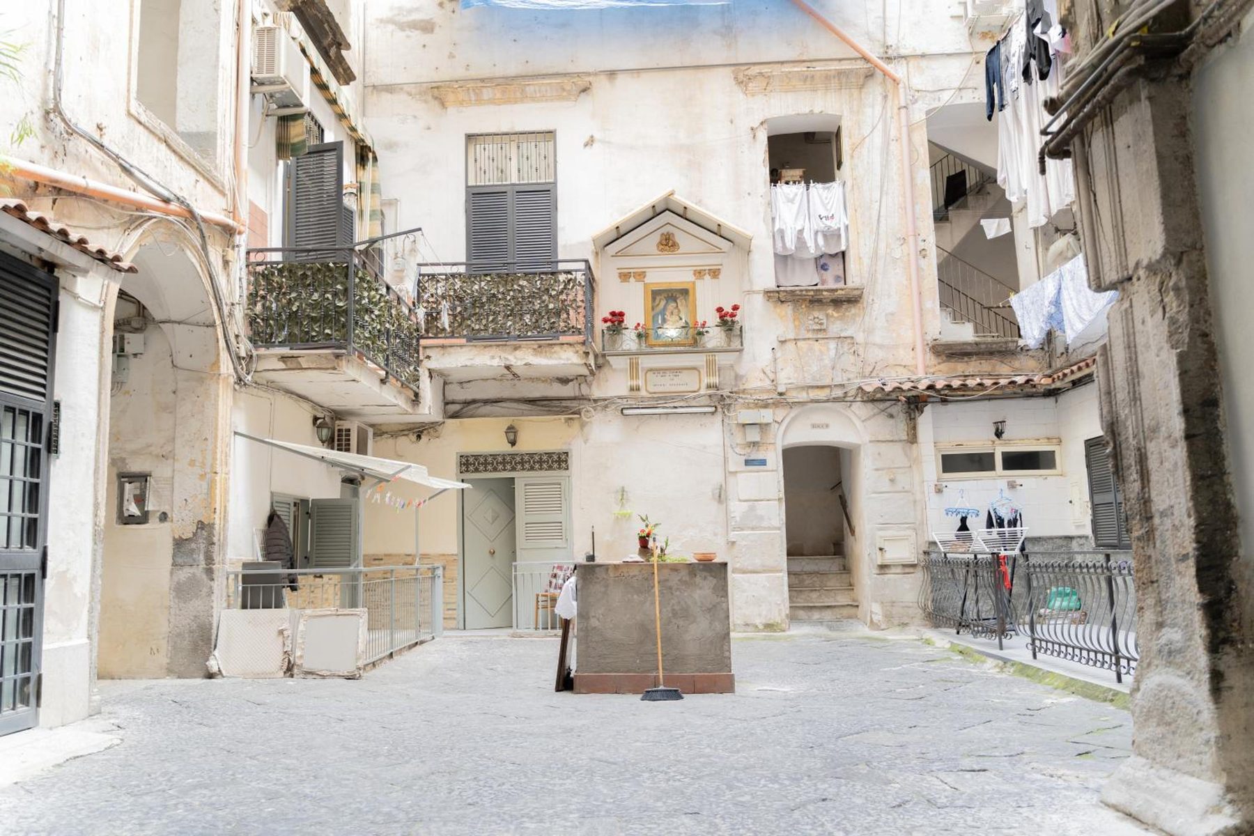 Il cortile del palazzo antico, coi balconi e i panni stesi