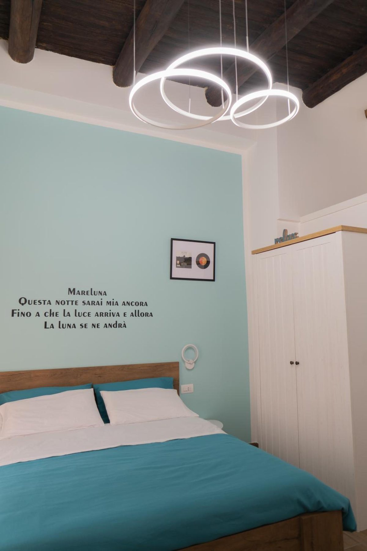 Mareluna: il letto, l'armadio bianco e la lampada a cerchi